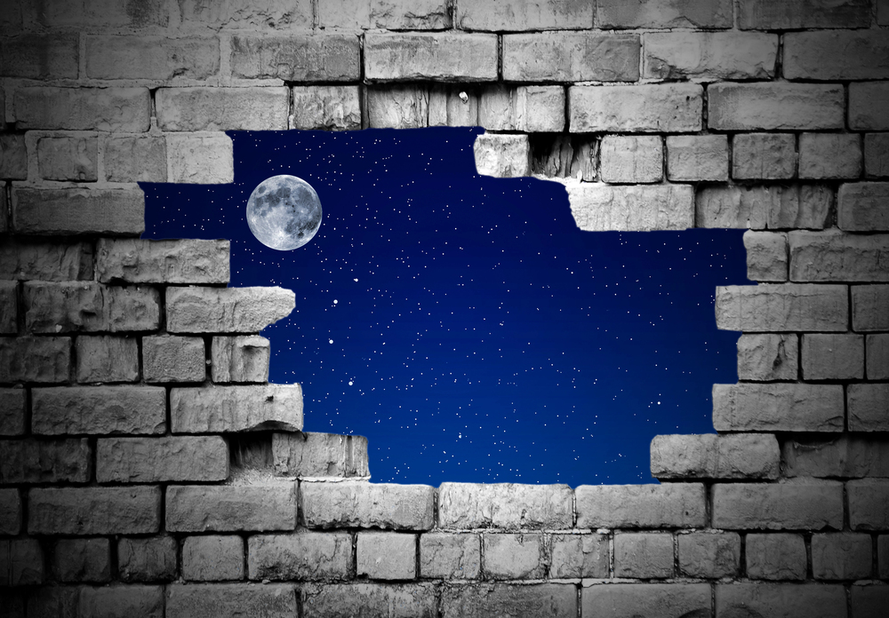 Bewachte Baustelle mit Baugerüsten und Beleuchtung bei Nacht.